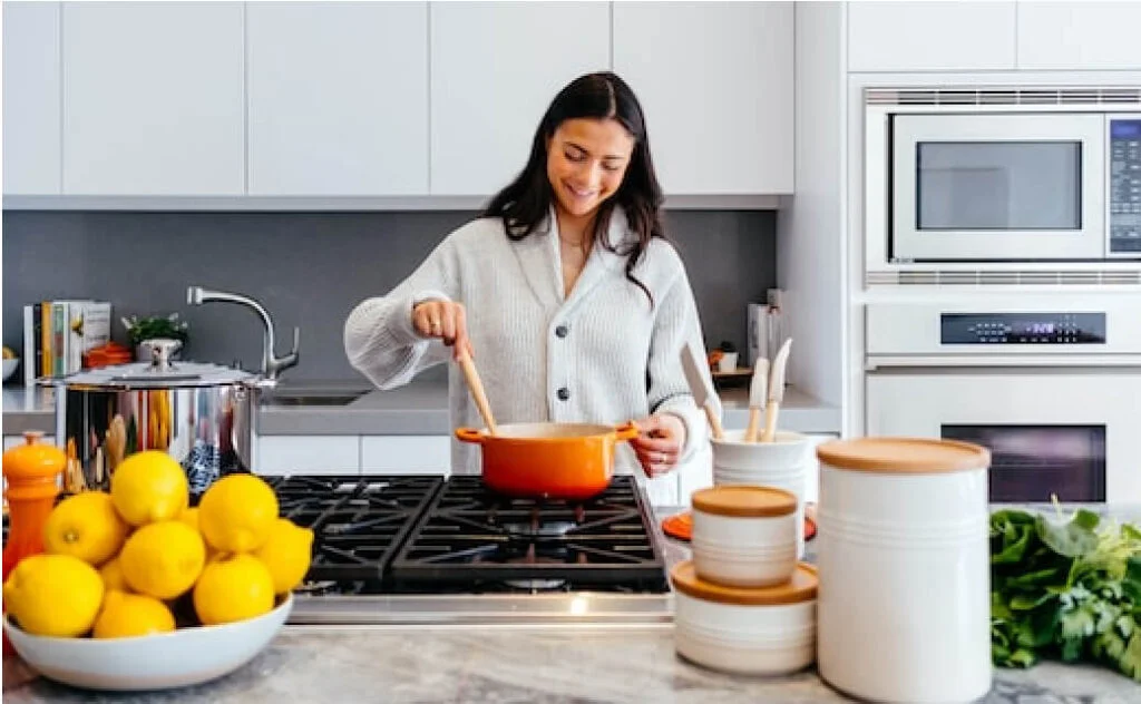 A woman is comparing quartz and granite countertops in a kitchen.