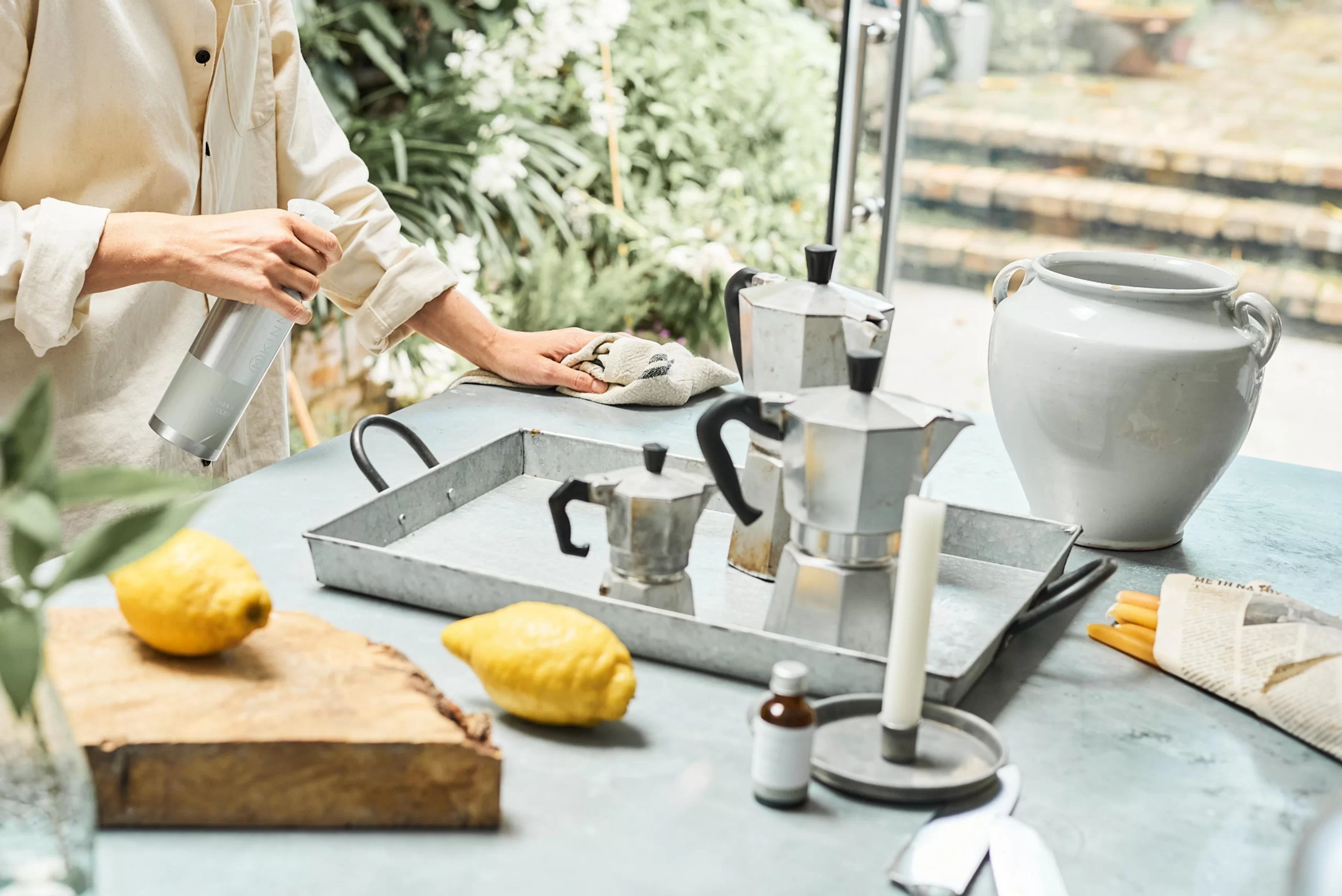 A woman is cleaning and caring for her quartz stone benchtop by preparing lemons on a counter.