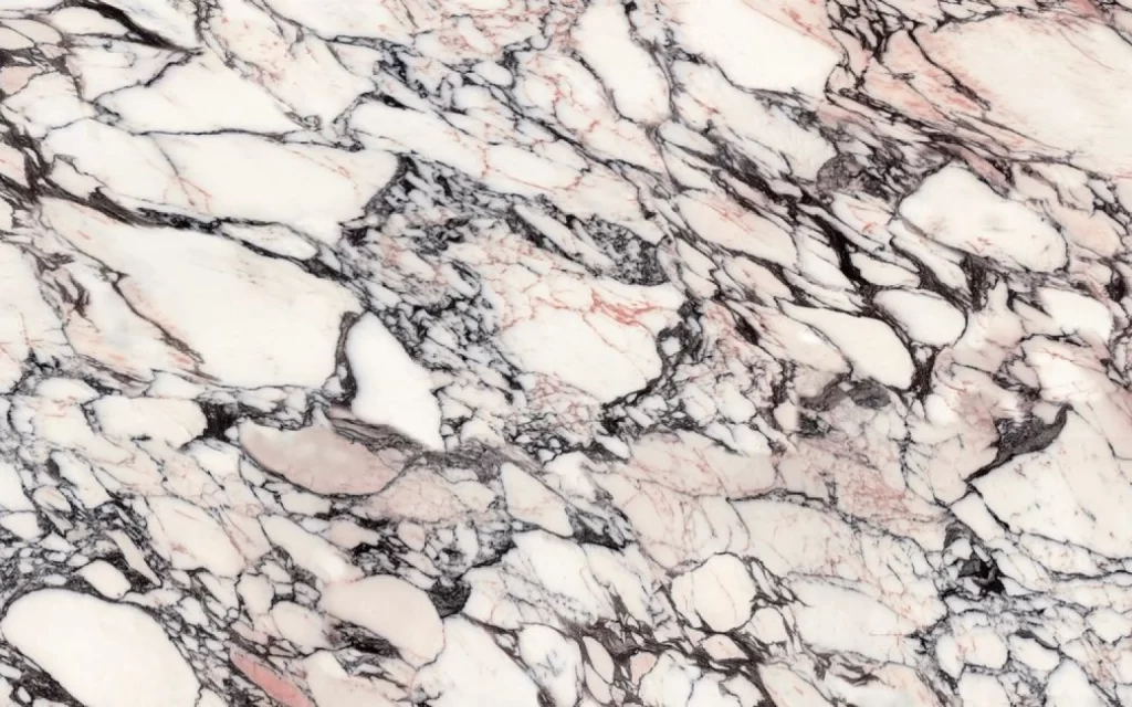 A close-up of a Calacatta marble surface featuring an intricate pattern of black, white, and subtle pink veins.