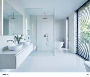 Modern bathroom with double sinks, a glass-enclosed shower, freestanding tub, large windows with blinds, and minimalistic white decor.